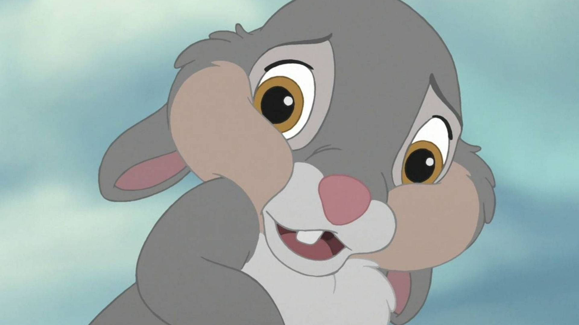 Thumper 桌布 壁紙 — 一隻開心的動畫兔子，有大大的棕色眼睛和粉紅色鼻子，在柔和的藍天背景中微笑。