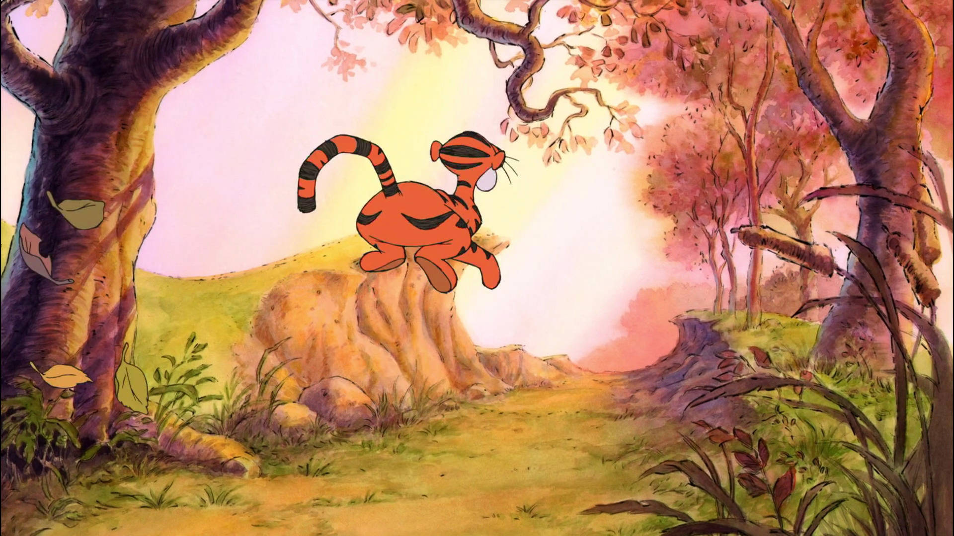 Tigger 桌布 壁紙 — 一隻開心的卡通老虎在陽光明媚的秋日森林中，從岩石上歡快地跳躍，周圍有粉紅色和橙色的樹葉。