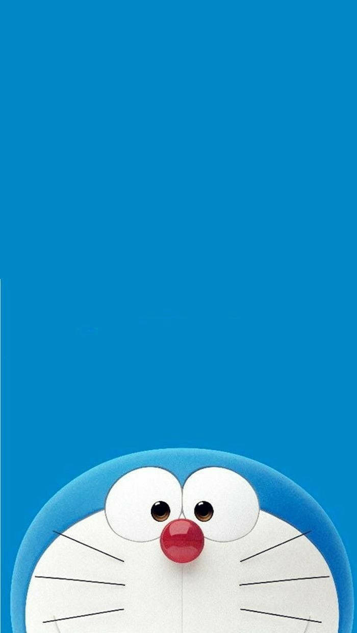 Doraemon 3d 桌布 壁紙 — 一隻開心的藍色機器貓從底部探出頭來，背景是純藍色。