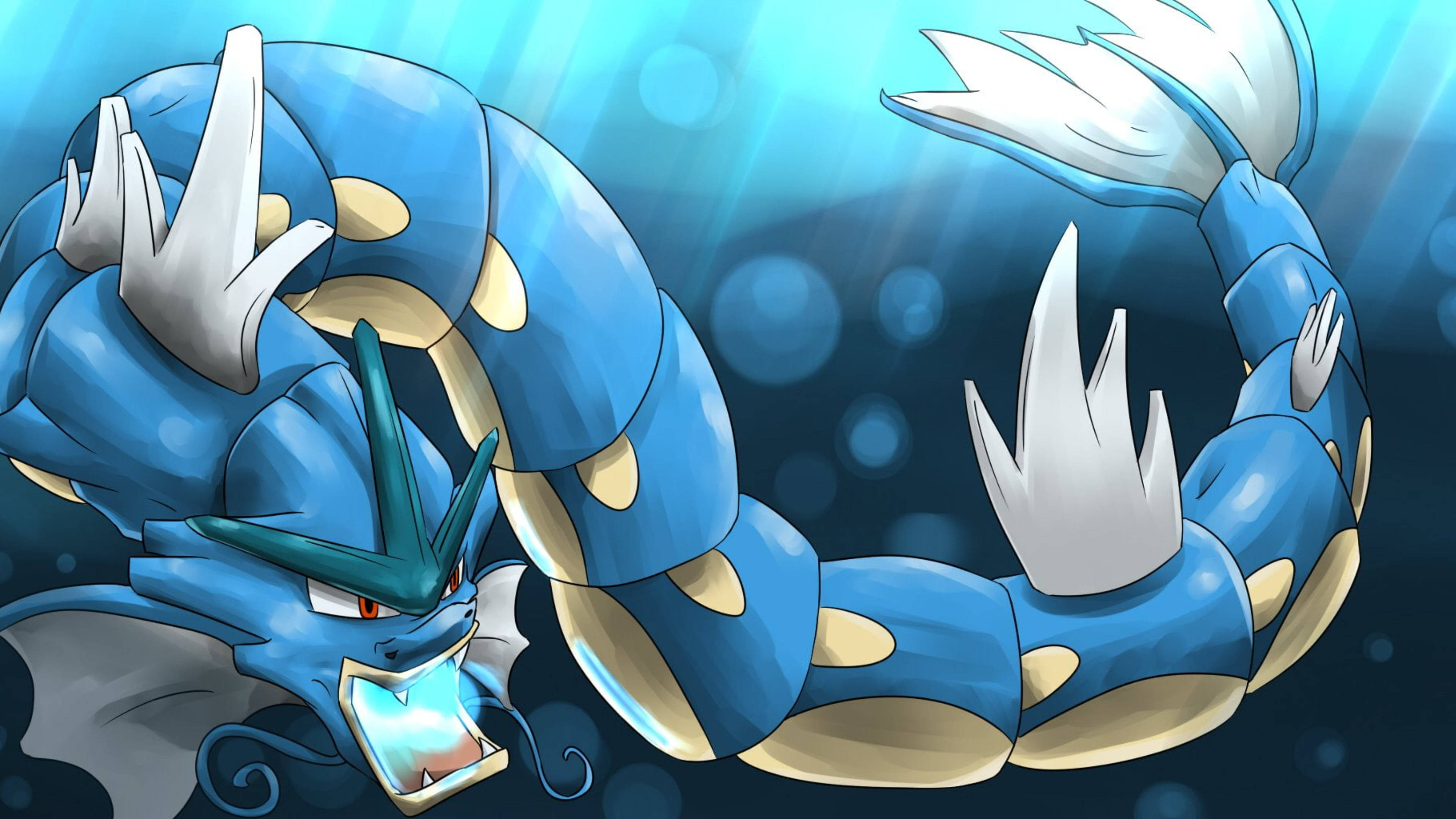 Gyarados 桌布 壁紙 — 一隻雄偉的藍色龍系寶可夢在水中動態盤旋，發光的眼睛和鋒利的白色鰭片映襯著燦爛的藍色背景。
