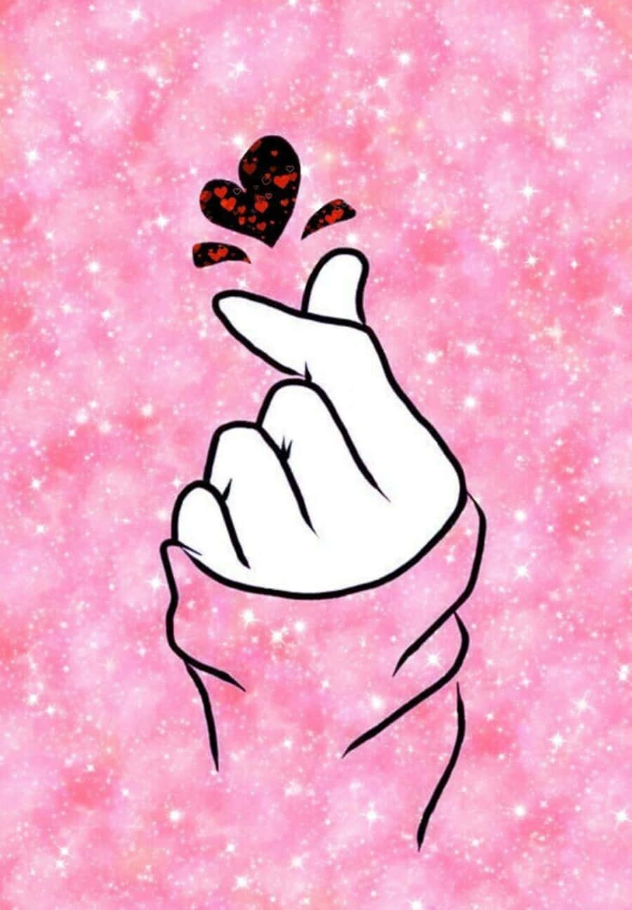 Kpop Kawaii 桌布 壁紙 — 一隻風格化的手在閃爍的粉紅色背景上做出心形手勢，周圍漂浮著心形。