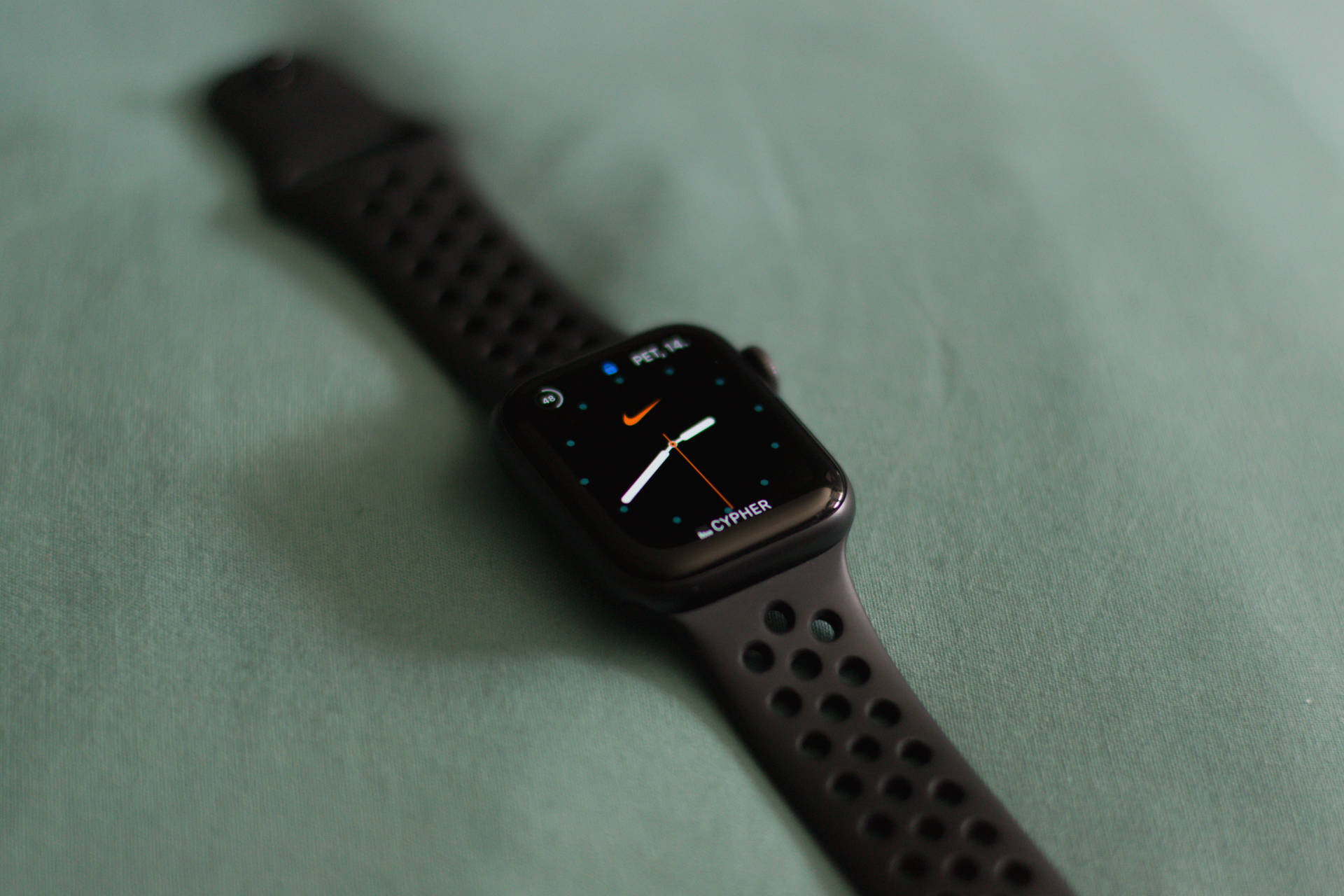 黑色Apple Watch配Nike錶面，綠色布料背景 — 智慧手錶 GIF 壁紙