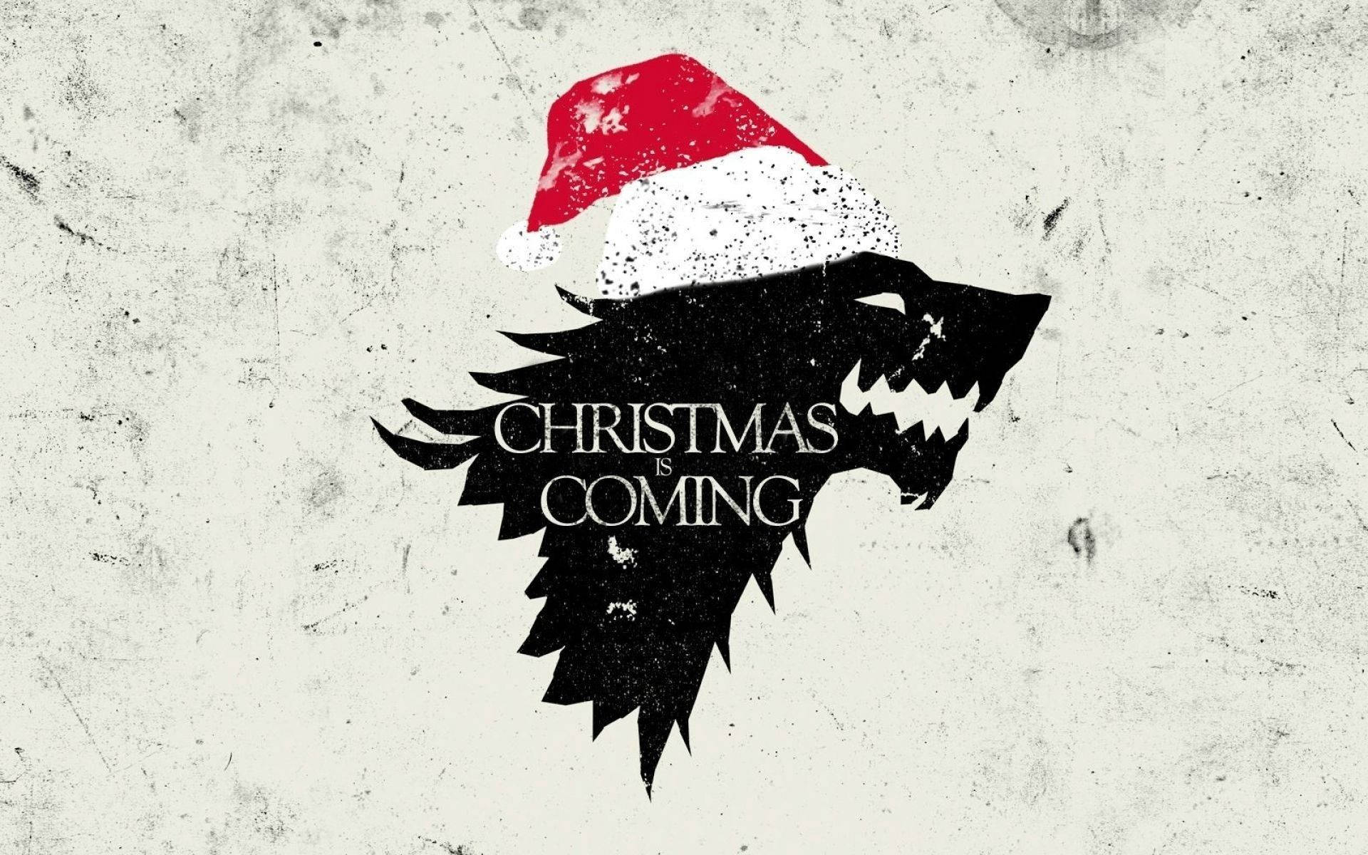 Christmas Movie 桌布 壁紙 — 一隻黑色冰原狼剪影，戴著紅白聖誕帽，背景為磨損的米白色，上面有「CHRISTMAS IS COMING」字樣。