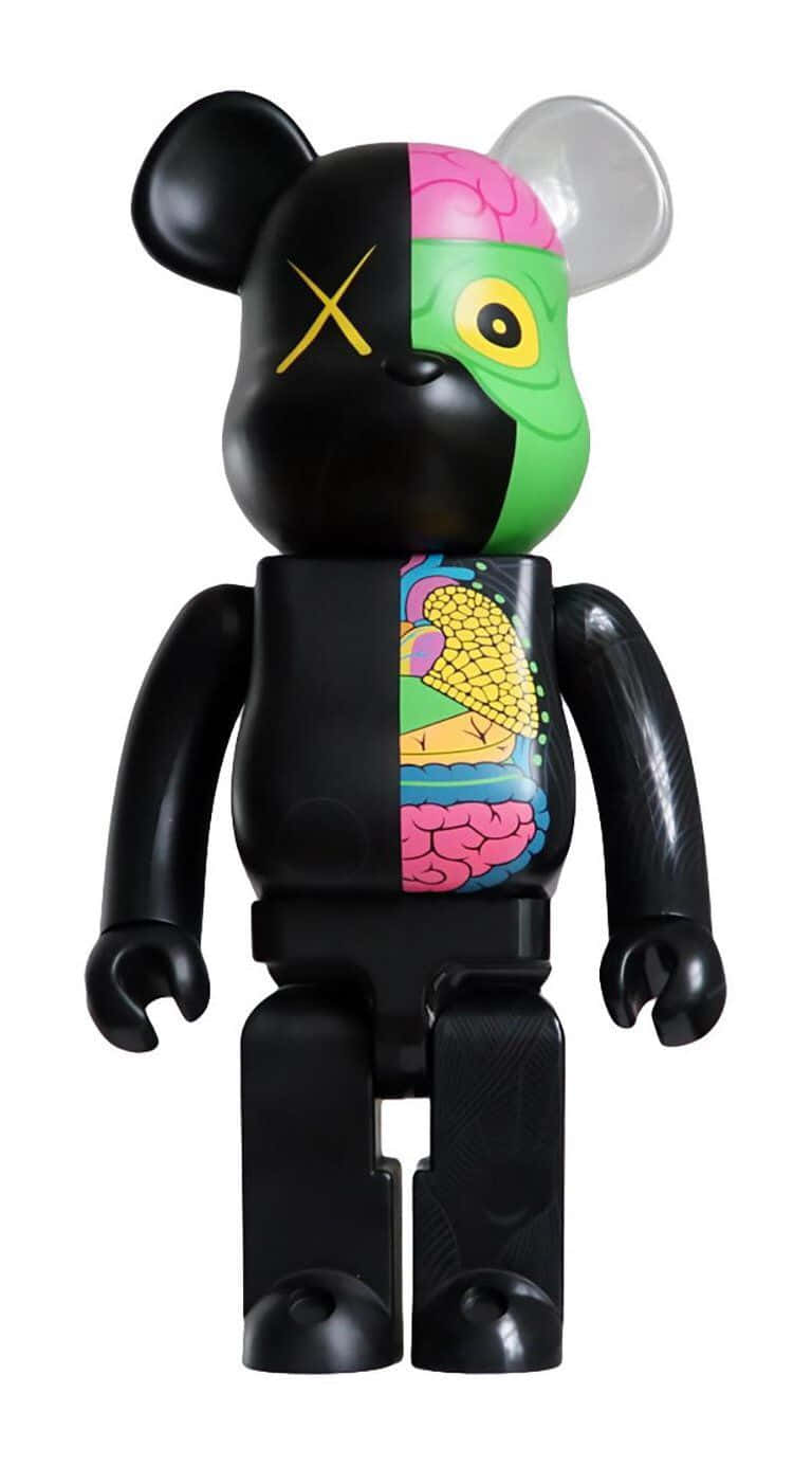 Kaws Bearbrick 桌布 壁紙 — 一隻黑色熊玩具從中間裂開，露出色彩繽紛的內臟和一個帶有黃色X的大腦在一側。