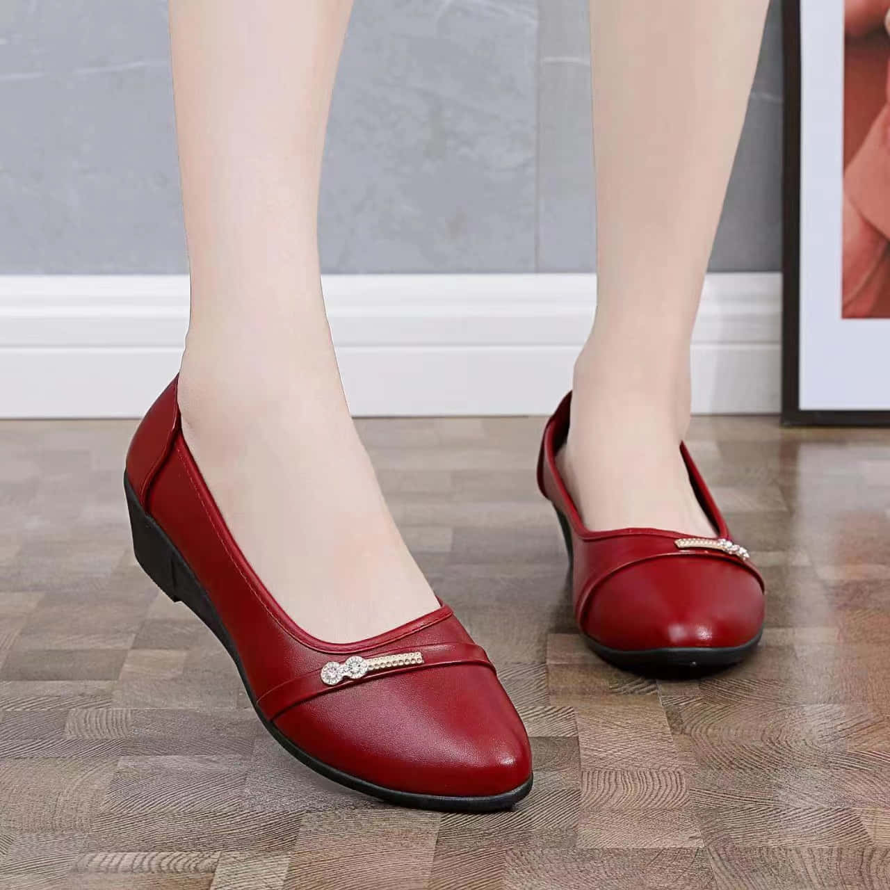 Red Shoes 桌布 壁紙 — 一雙優雅的紅色皮革女裝平底鞋，飾有寶石帶，放在灰色牆壁前的木地板上。
