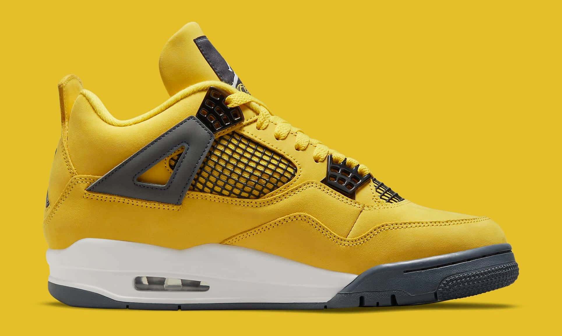 Yellow Jordan 桌布 壁紙 — 一雙大膽的黃色Jordan 4運動鞋，帶有黑色點綴和白色鞋底，在純黃色背景上脫穎而出。