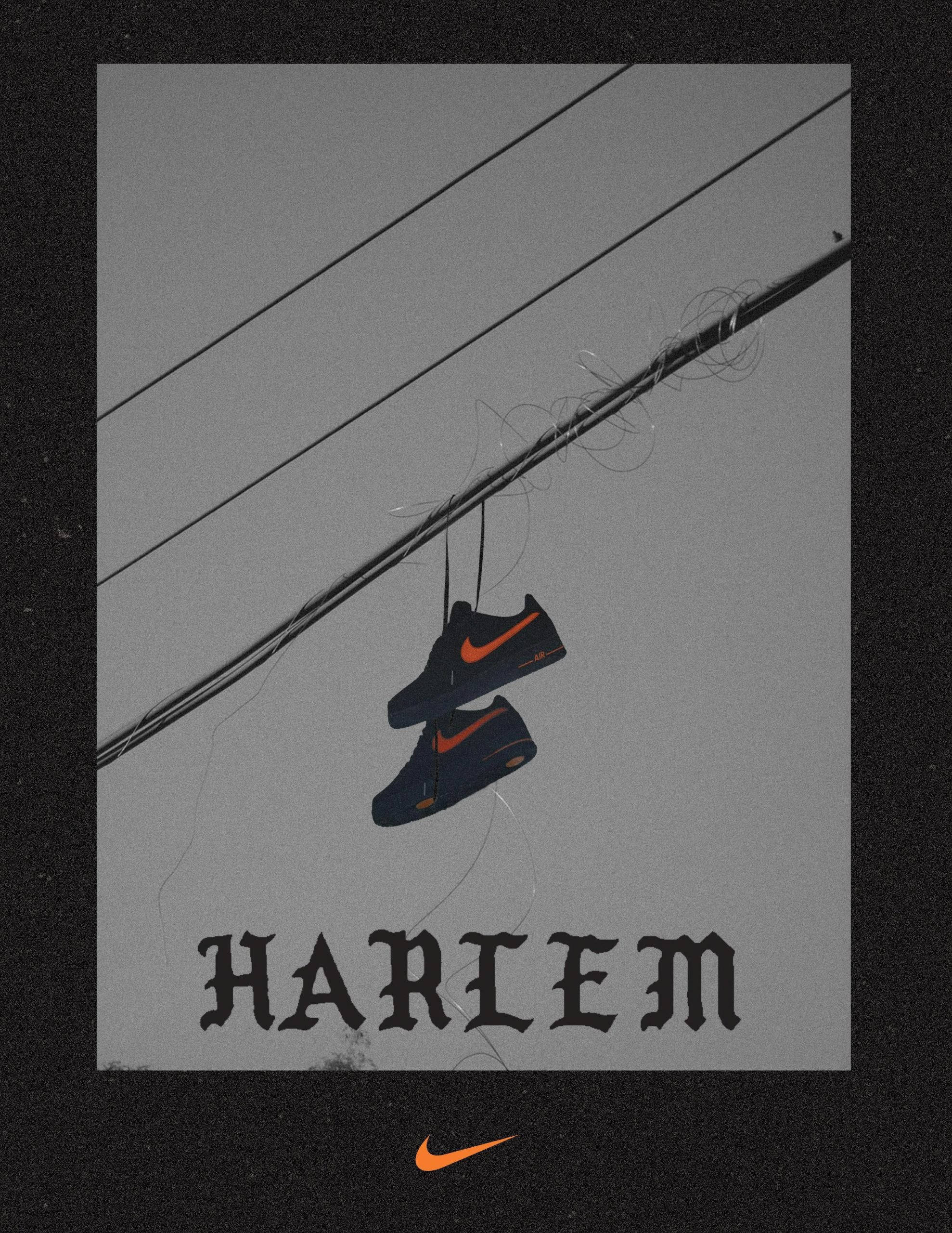 Vlone 桌布 壁紙 — 一雙帶有橙色swoosh的黑色Nike運動鞋掛在纏繞的電線上，背景是灰色天空，下方有'HARLEM'文字。