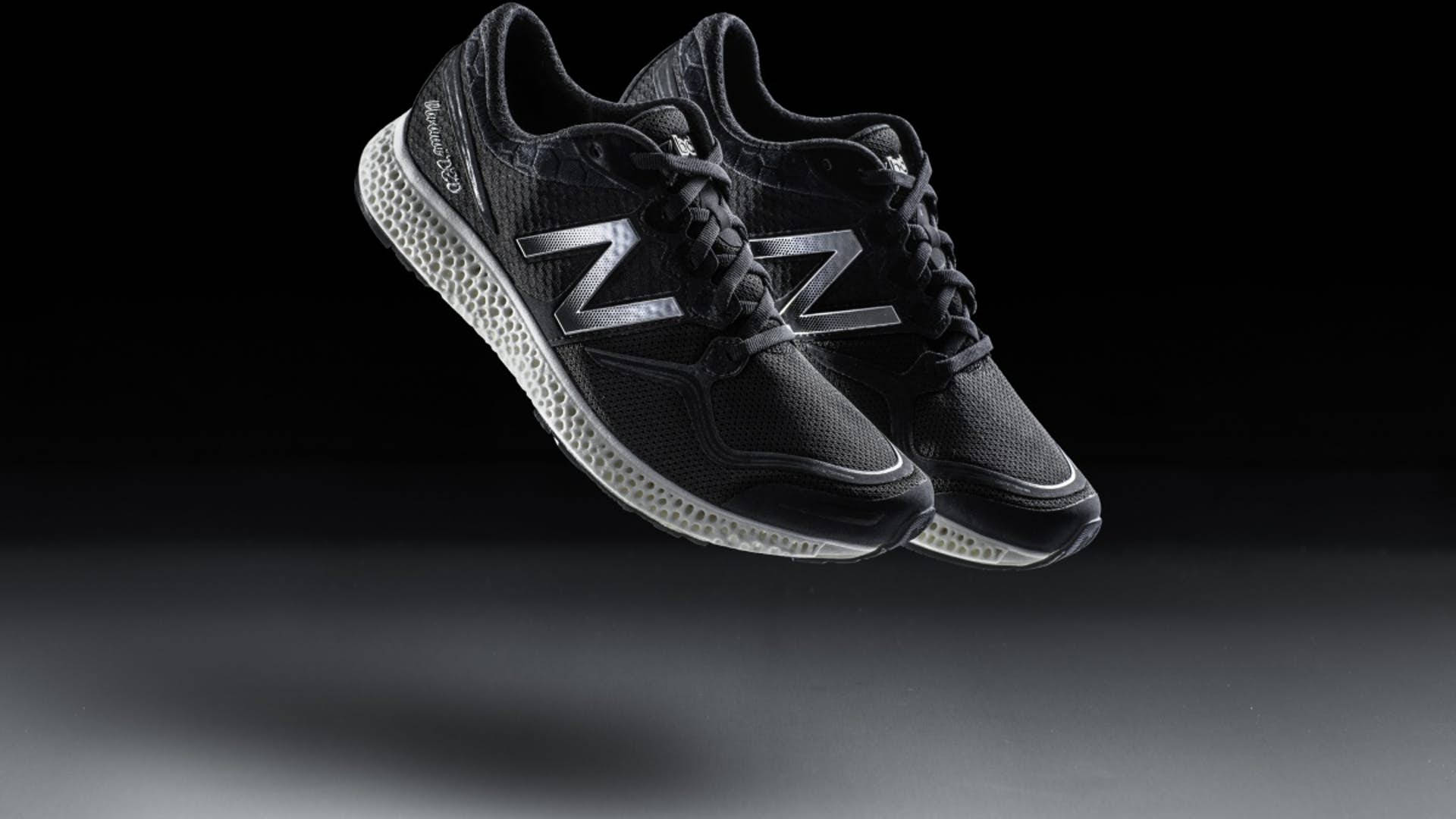 New 桌布 壁紙 — 一雙帶有銀色標誌的黑色 New Balance 運動鞋在深色漸變背景上漂浮。