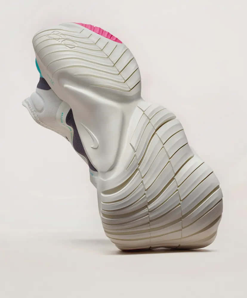 Nike 桌布 壁紙 — 一雙時尚的白色Nike運動鞋，帶有粉紅色和藍綠色點綴，從動態的後方角度展示在極簡背景上。