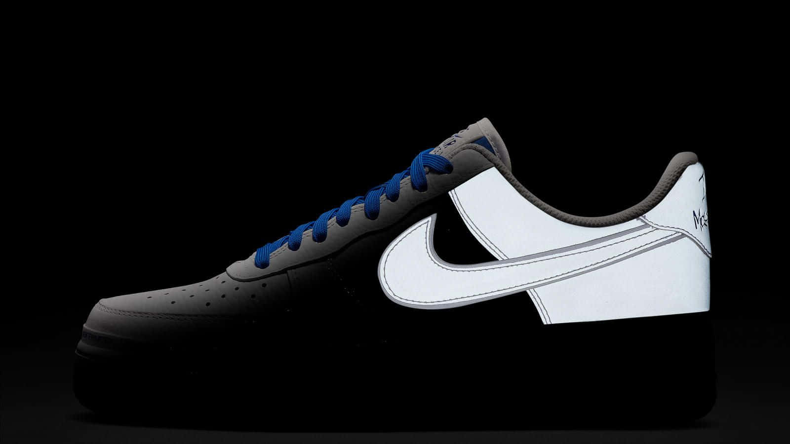 桌布 壁紙 — 一雙時尚的黑白Nike Air Force 1運動鞋，搭配鮮豔的藍色鞋帶，在純黑色背景上脫穎而出。