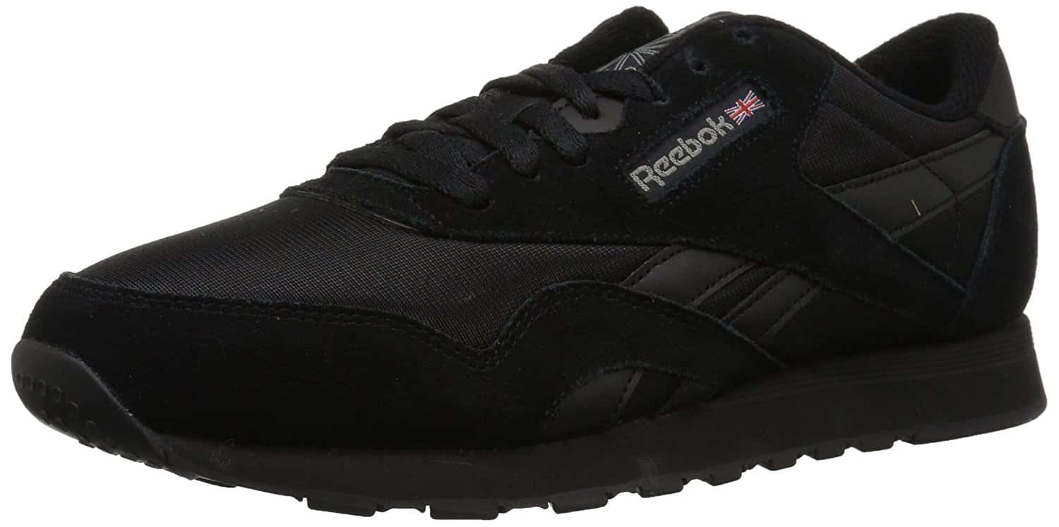 Reebok 桌布 壁紙 — 一雙時尚的黑色 Reebok 運動鞋，採用紋理布料和橡膠鞋底，在工作室燈光下展示。