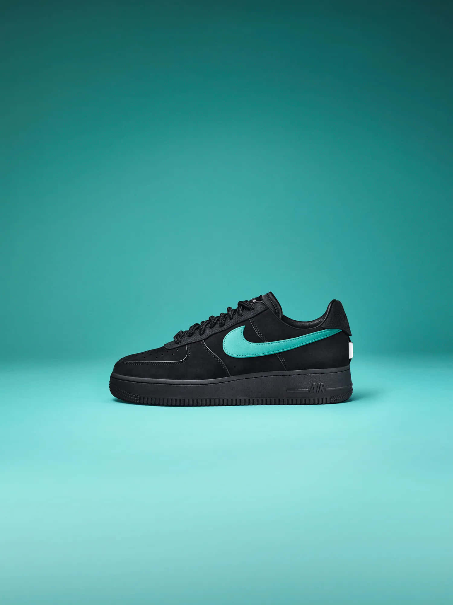 Nike 桌布 壁紙 — 一雙時尚的黑色Nike Air Force 1運動鞋，帶有充滿活力的青綠色swoosh，居中放置在漸變青綠色背景上。