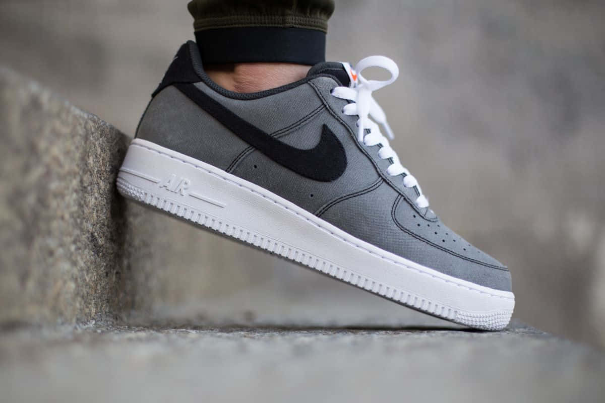 Nike Air Force 桌布 壁紙 — 一雙灰色Nike Air Force 1運動鞋搭配白色鞋帶，靠著紋理石緣，展現簡潔線條與都市風格。