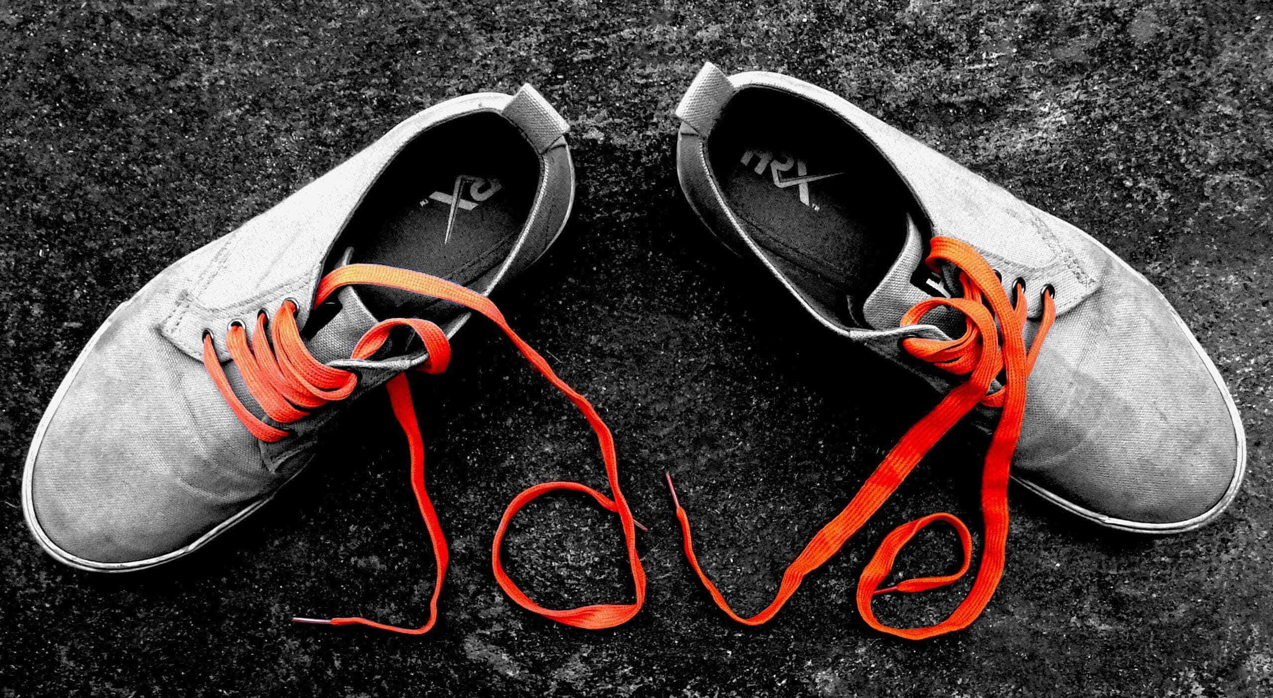 Cute Shoes 桌布 壁紙 — 一雙灰色運動鞋，帶有鮮豔的橙色鞋帶，在深色紋理表面上排列成 love 字樣。