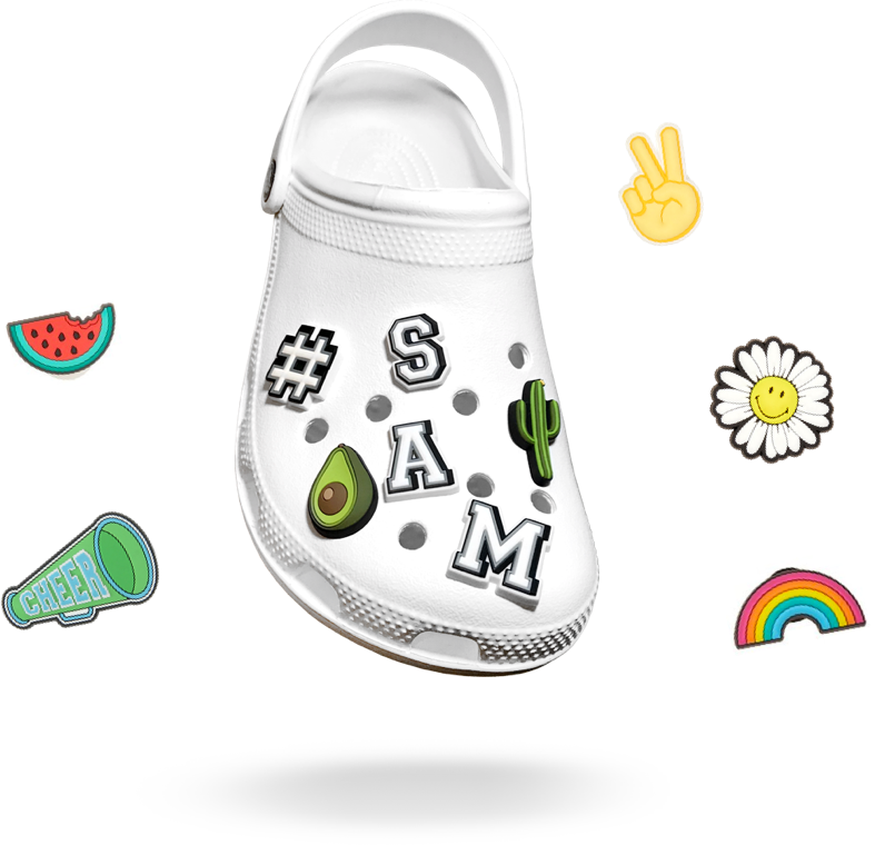 Crocs 桌布 壁紙 — 一雙白色 Croc 木屐，裝飾著色彩繽紛的貼紙，包括酪梨、仙人掌、名字和歡呼符號，背景為黑色。
