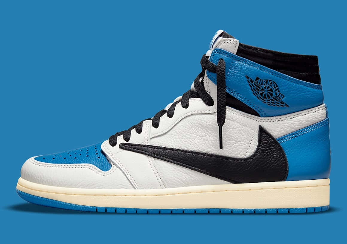 Travis Scott Jordan 1 桌布 壁紙 — 一雙白色、黑色和鮮藍色的高筒Air Jordan運動鞋，置於純藍色背景前。