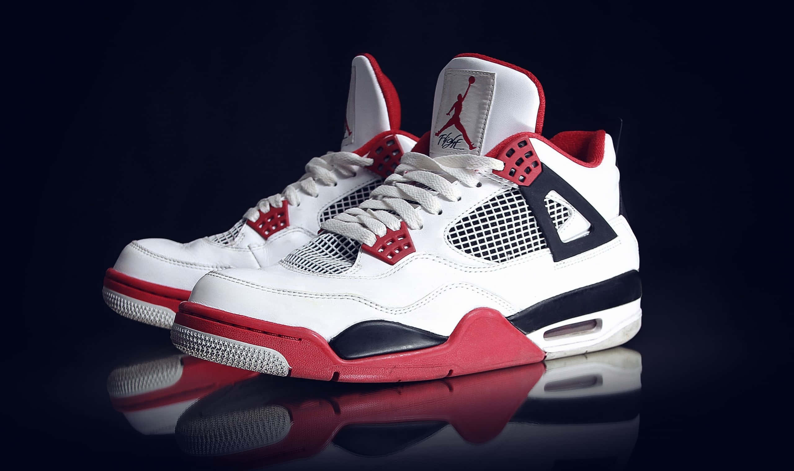 一雙白色與紅色的Air Jordan 4運動鞋 壁紙