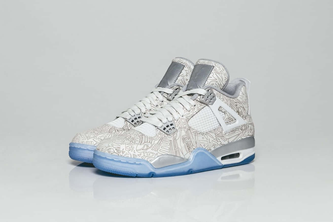 Sneaker 桌布 壁紙 — 一雙白色高筒運動鞋，帶有複雜的灰色塗鴉圖案和淺藍色鞋底，放置在反光的白色表面上。