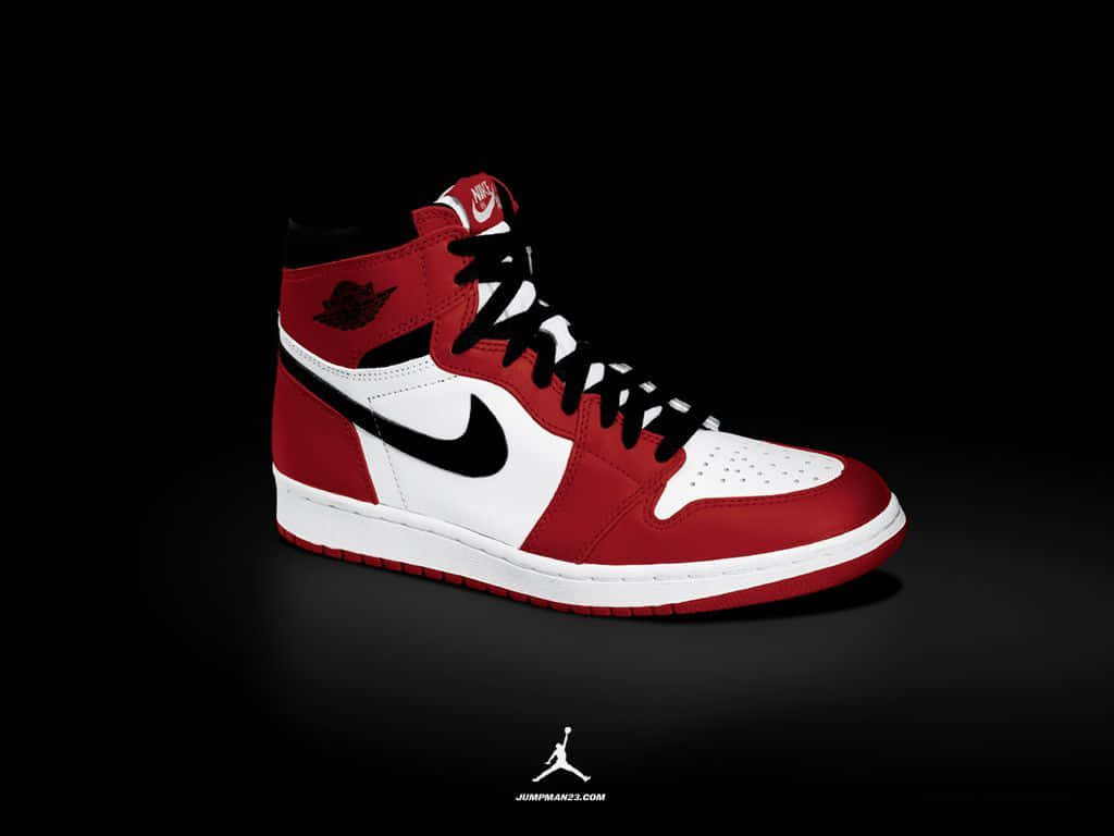 Air Jordan 1 桌布 壁紙 — 一雙紅、白、黑色高筒運動鞋，帶有標誌性 swoosh 和標誌，居中放置在純黑色背景上。