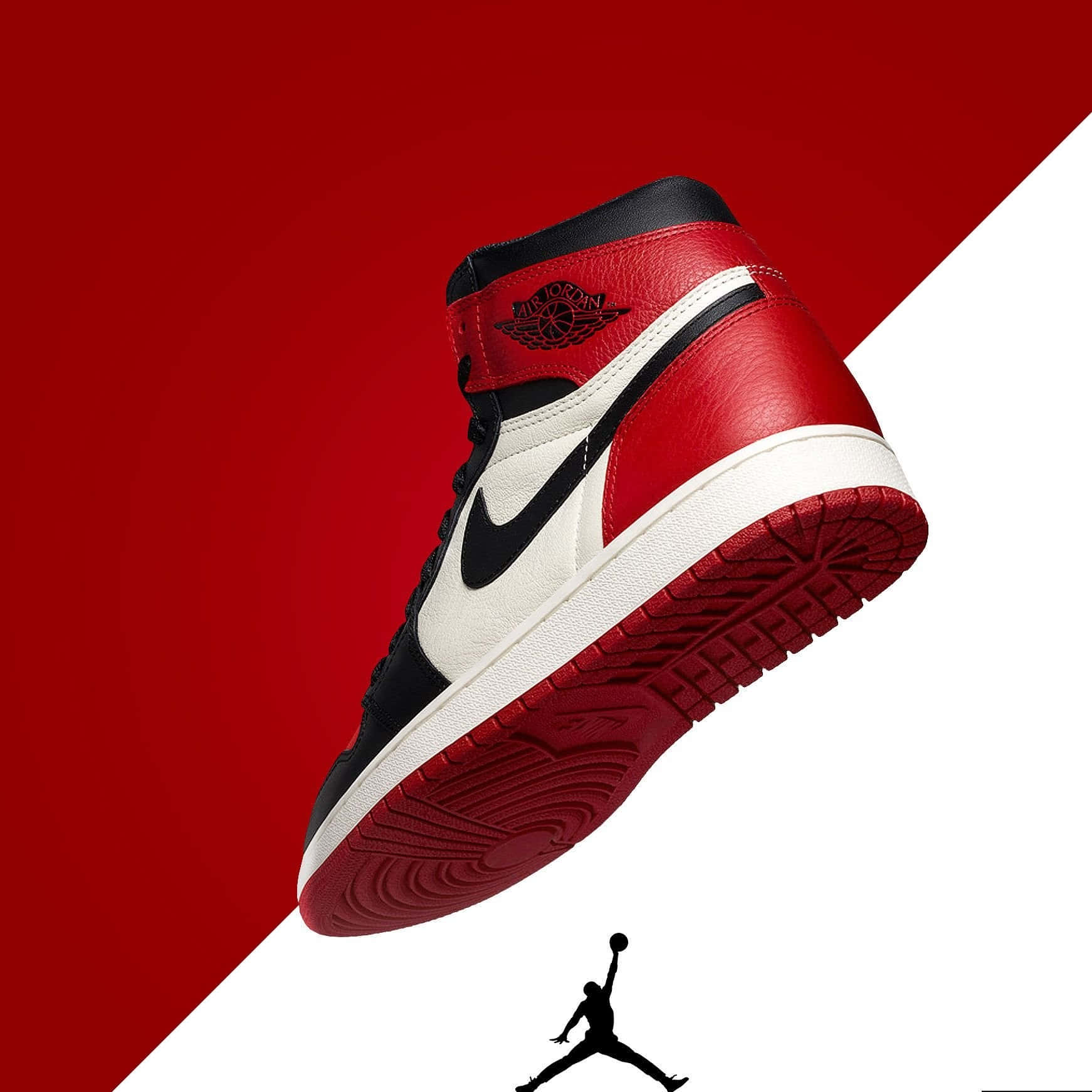 桌布 壁紙 — 一雙紅、黑、白色的 Air Jordan 1 運動鞋以對角線漂浮在搶眼的紅白分割背景上，下方有 Jumpman 剪影。