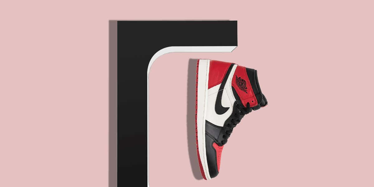 Sneakerhead 桌布 壁紙 — 一雙紅、黑、白色高筒運動鞋懸掛在極簡黑色和粉紅色背景上。