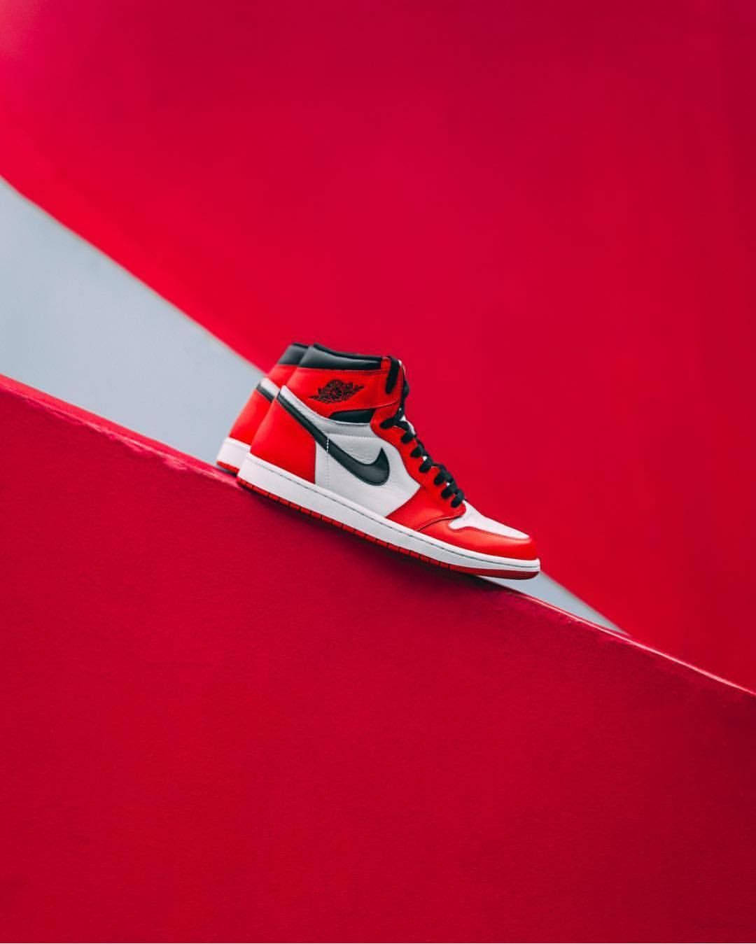 Nike Air Jordan 1 桌布 壁紙 — 一雙紅白黑高筒運動鞋放置在鮮明的紅白斜紋表面上。