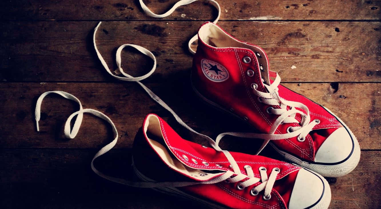 Red Shoes 桌布 壁紙 — 一雙紅色高筒Converse運動鞋，鞋帶未繫，放在磨損的木地板上。