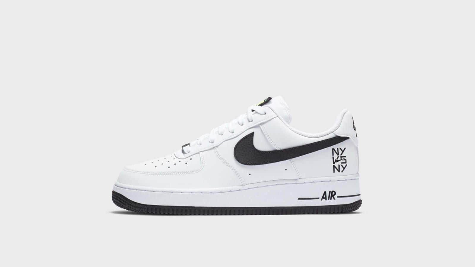 桌布 壁紙 — 一雙純白色的Nike Air Force 1運動鞋，帶有醒目的黑色Swoosh標誌和文字細節，背景為乾淨的灰色。