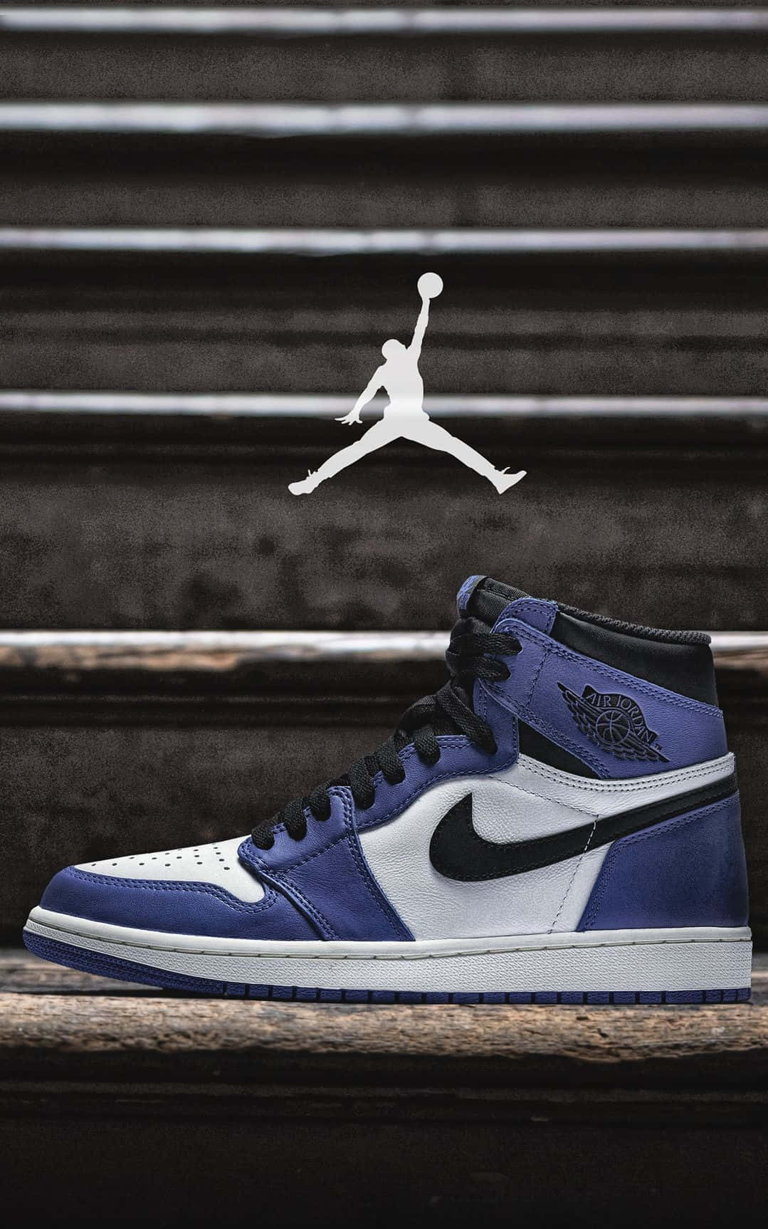 Jordan球鞋 桌布 壁紙 — 一雙藍白色Jordan 1球鞋放在經風化的木樓梯上，上方浮現白色Jumpman標誌。