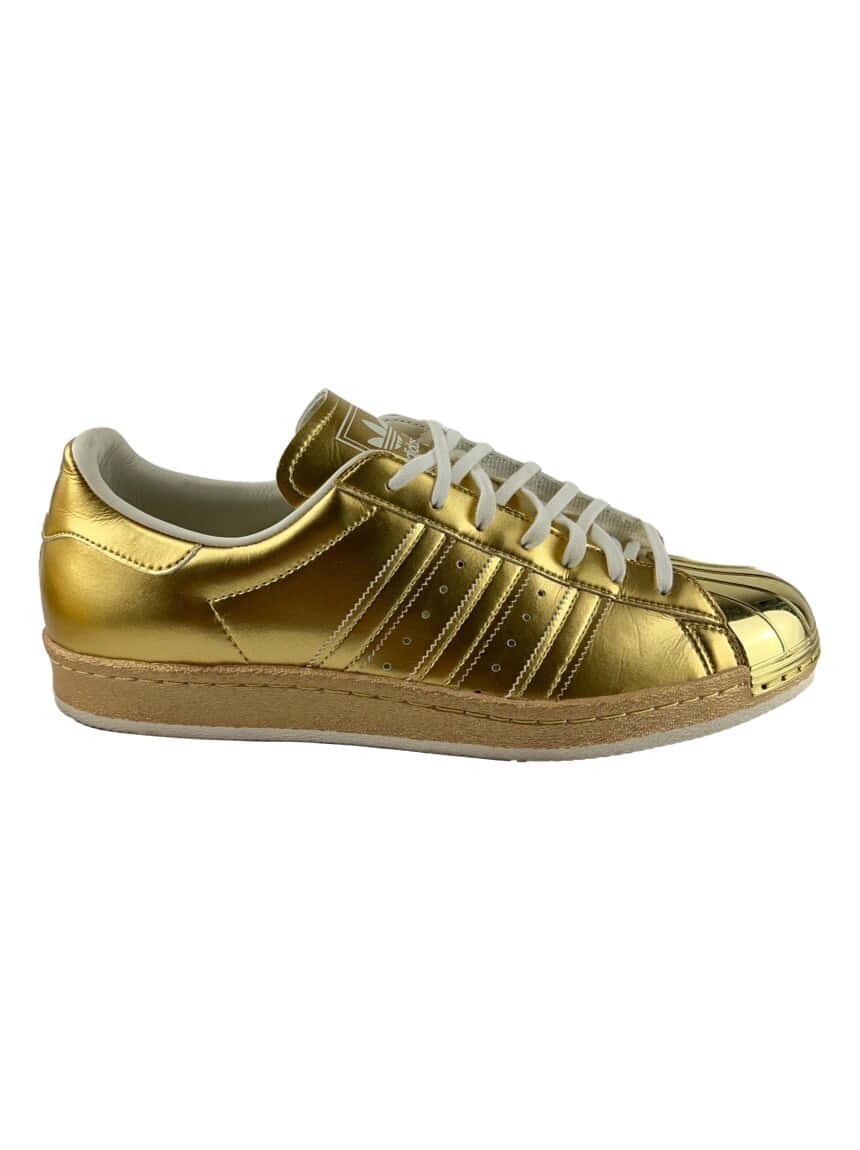 金屬質感 桌布 壁紙 — 一雙閃亮的金色Adidas Superstar運動鞋，配有白色鞋帶和橡膠鞋底，背景為純白色。