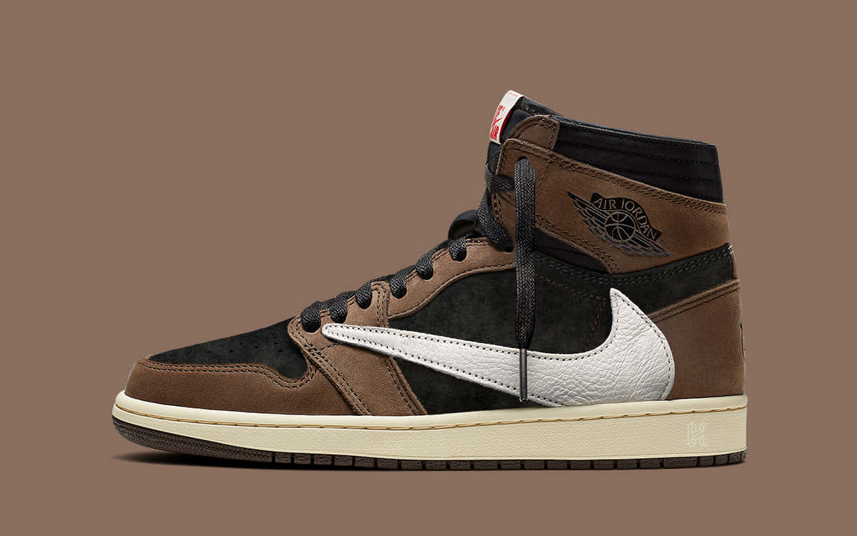 Air Jordan 1 桌布 壁紙 — 一雙高筒運動鞋，帶有棕色、黑色和白色拼接，立在純棕色背景前。