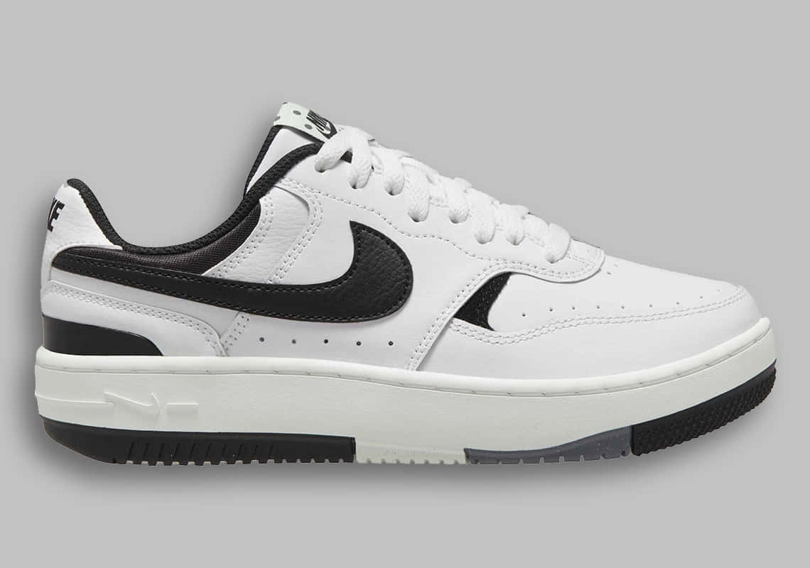 Nike 桌布 壁紙 — 一雙鮮明的白色Nike運動鞋，帶有醒目的黑色點綴和厚底，置於中性灰色背景上。