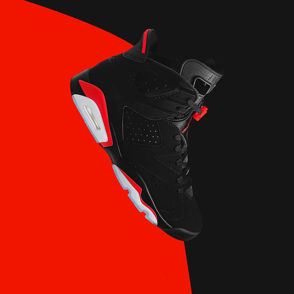 Sneakers 桌布 壁紙 — 一雙黑紅色的Jordan 6運動鞋以對角線方式漂浮在鮮明的紅黑分割背景上。