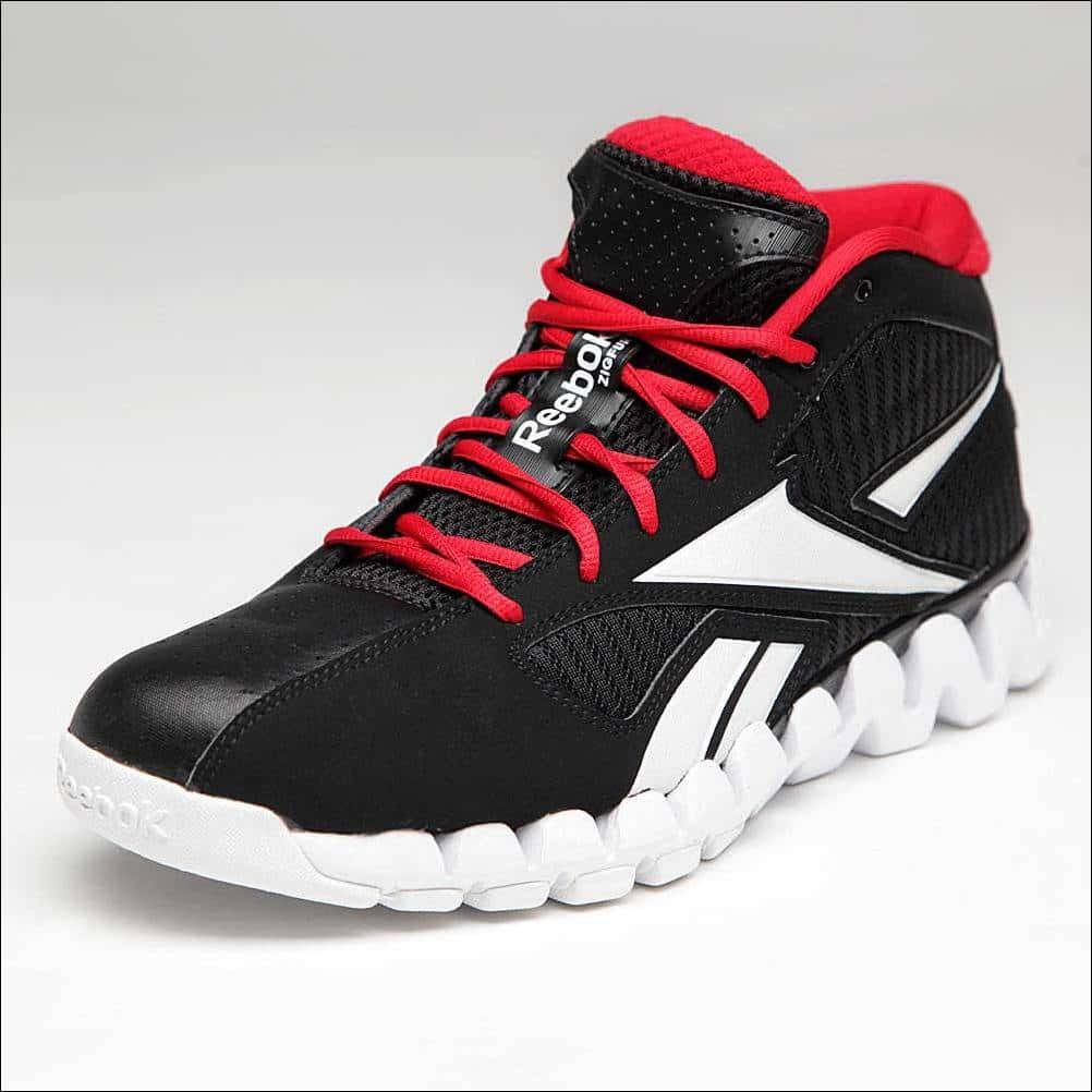 Reebok 桌布 壁紙 — 一雙黑色 Reebok 高筒運動鞋，紅色鞋帶，白色鞋底，純白背景。