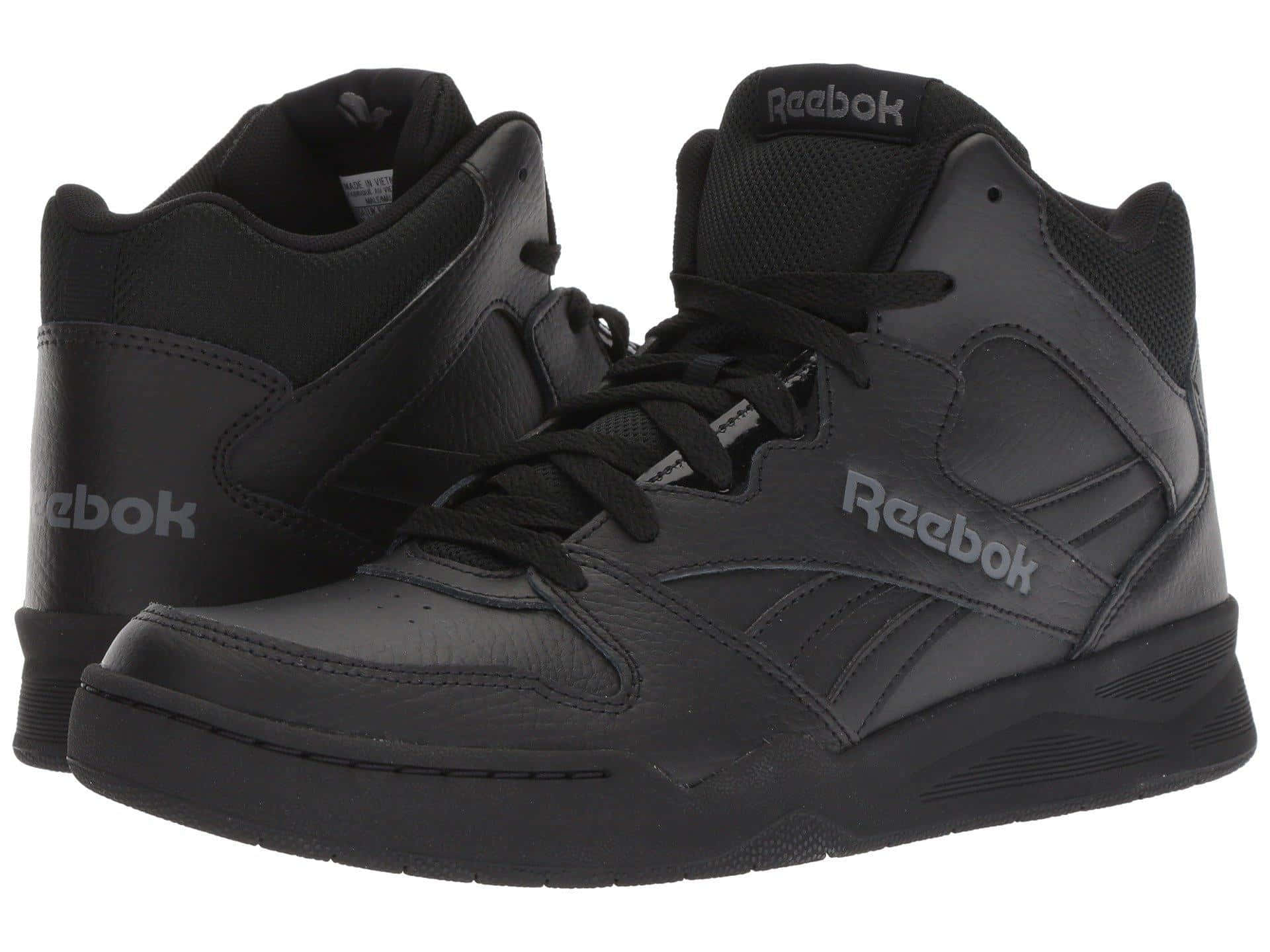 Reebok 桌布 壁紙 — 一雙黑色 Reebok 高筒運動鞋，帶有灰色點綴和鞋帶，展示在乾淨的白色背景上。