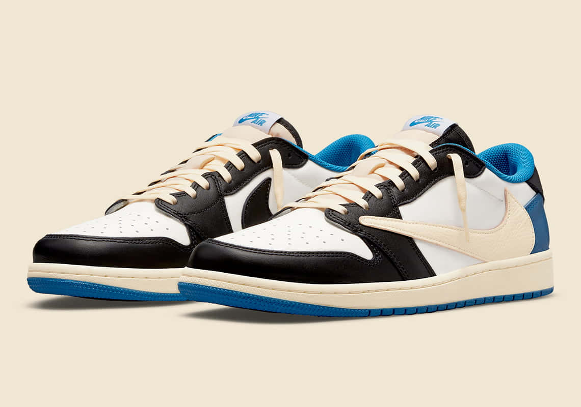 Travis Scott Jordan 1 桌布 壁紙 — 一雙黑色、白色和藍色的Nike Air Jordan運動鞋，搭配奶油色鞋帶和米色背景。