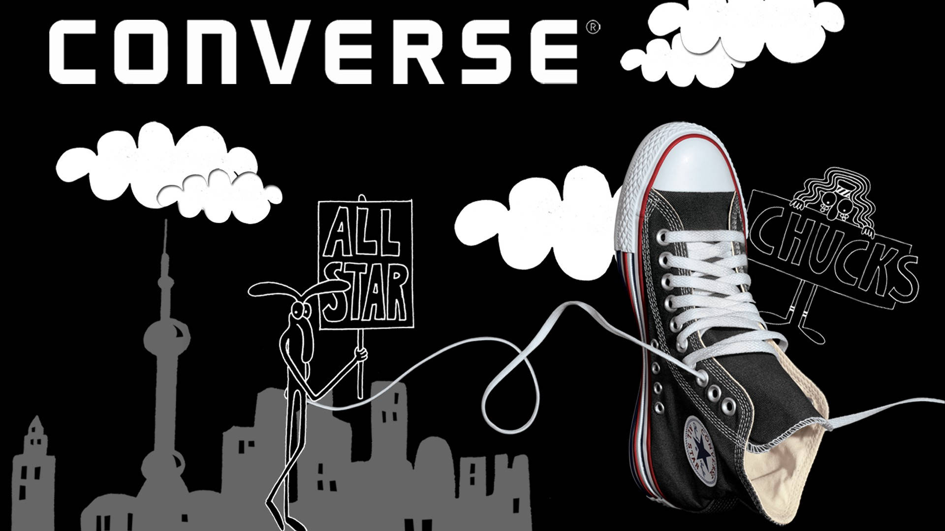 Converse 標誌 桌布 壁紙 — 一雙黑色Converse Chuck Taylor運動鞋漂浮在黑色背景上，有白色雲朵和卡通人物舉著寫有「ALL STAR」和「CHUCKS」的標語牌，上方是灰色的城市天際線。