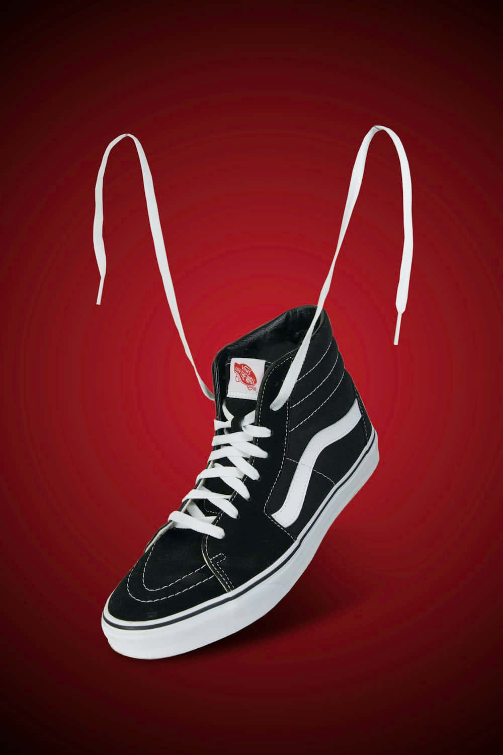 Vans 桌布 壁紙 — 一雙黑色Vans高筒運動鞋，帶白色鞋帶和鞋底，漂浮在鮮豔的紅色漸變背景上。