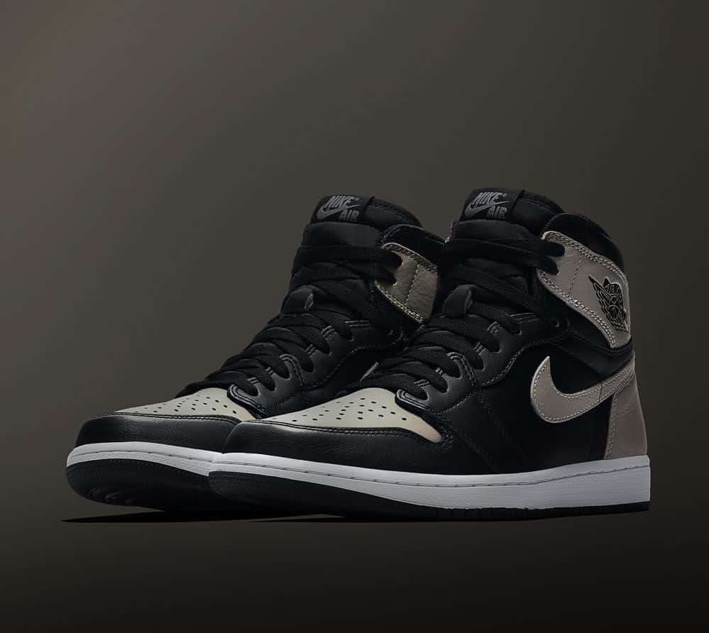 Travis Scott Jordan 1 桌布 壁紙 — 一雙黑色和米色高筒運動鞋，白色鞋底，展示在深色漸變背景上。
