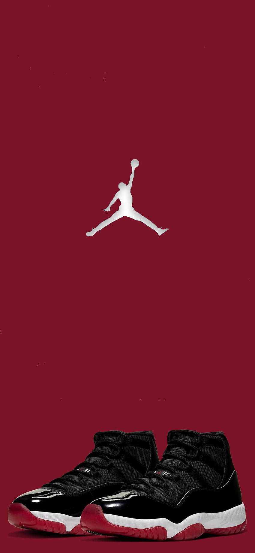Jordan球鞋 桌布 壁紙 — 一雙黑色和紅色的 Air Jordan 11 運動鞋放在深紅色背景上的白色 Jumpman 標誌下方。