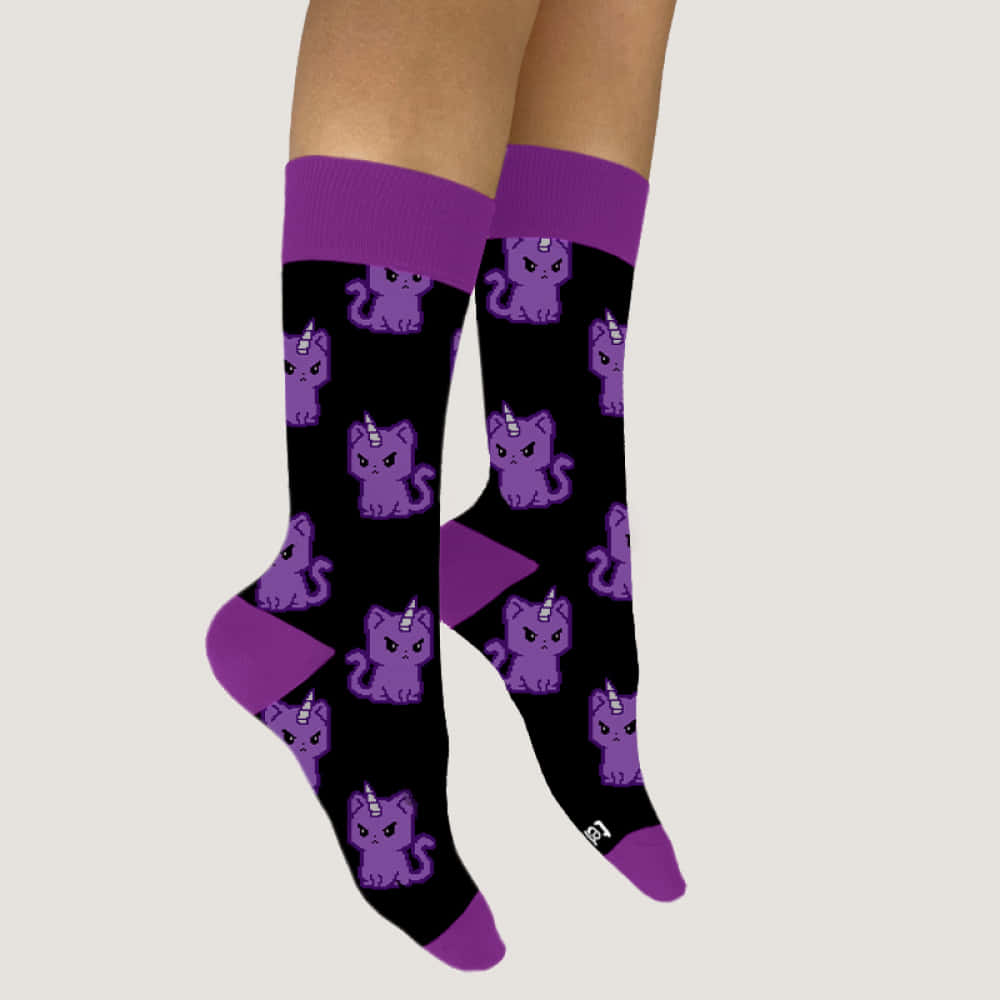 Purple Socks 桌布 壁紙 — 一雙黑色襪子，帶有紫色獨角貓圖案和紫色飾邊，穿在腿上，背景為純色。