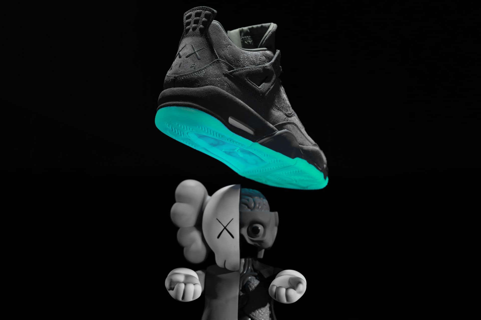 Kaws X Air Jordan 桌布 壁紙 — 一雙黑色運動鞋帶有發光青色鞋底，懸浮在KAWS公仔上方，背景為純黑色。