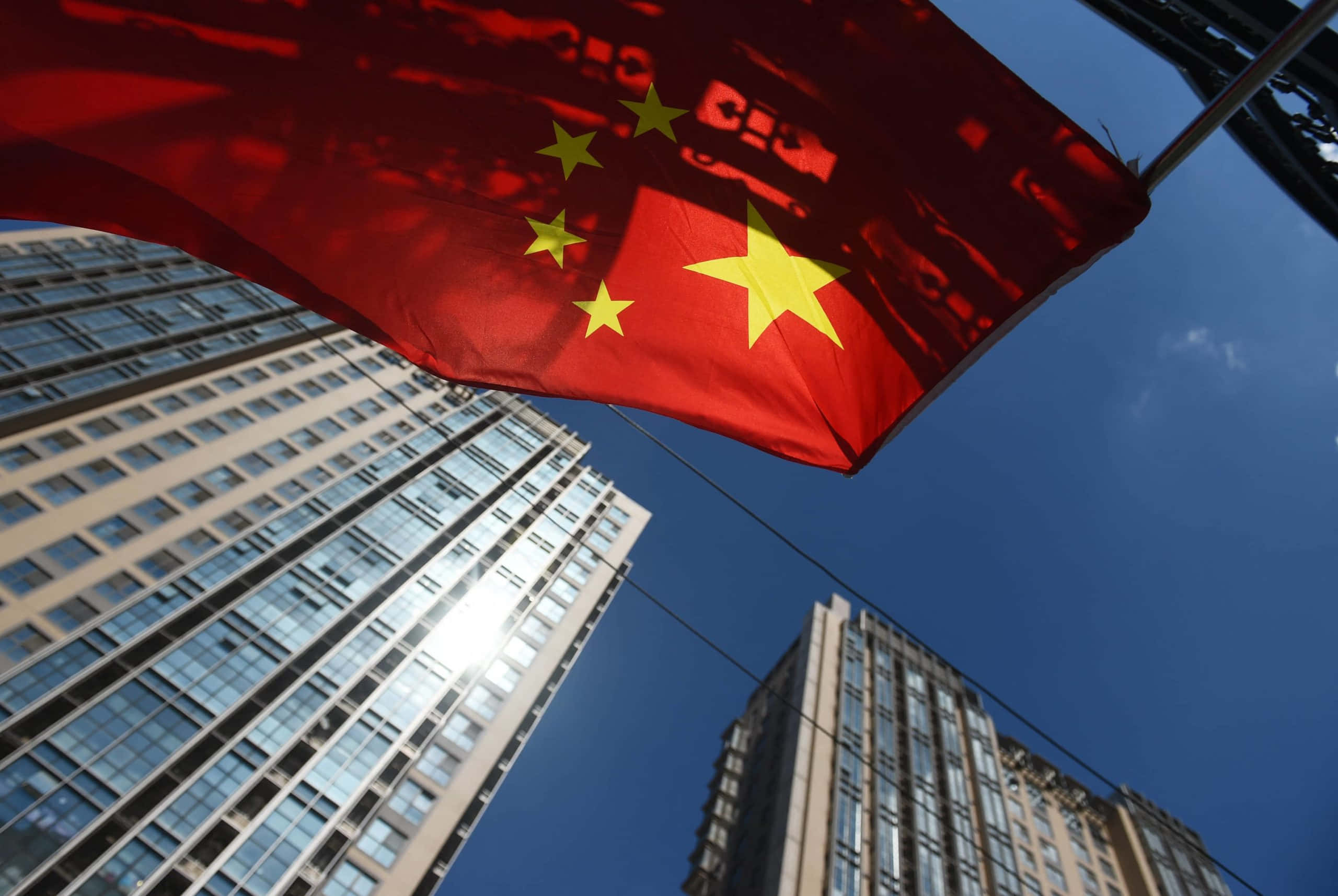 一面中國國旗在高樓大廈前飄揚 壁紙