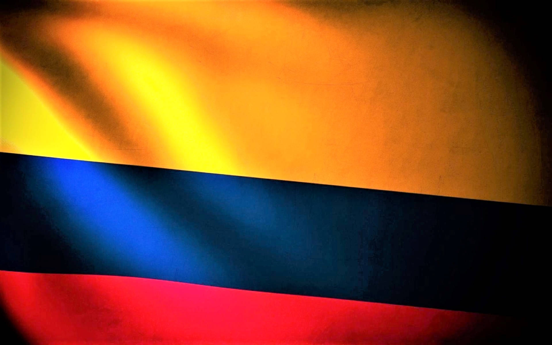 Colombia Flag 桌布 壁紙 — 一面充滿活力的哥倫比亞國旗，帶有鮮明的黃色、藍色和紅色條紋，在深色紋理背景上溫暖地發光。