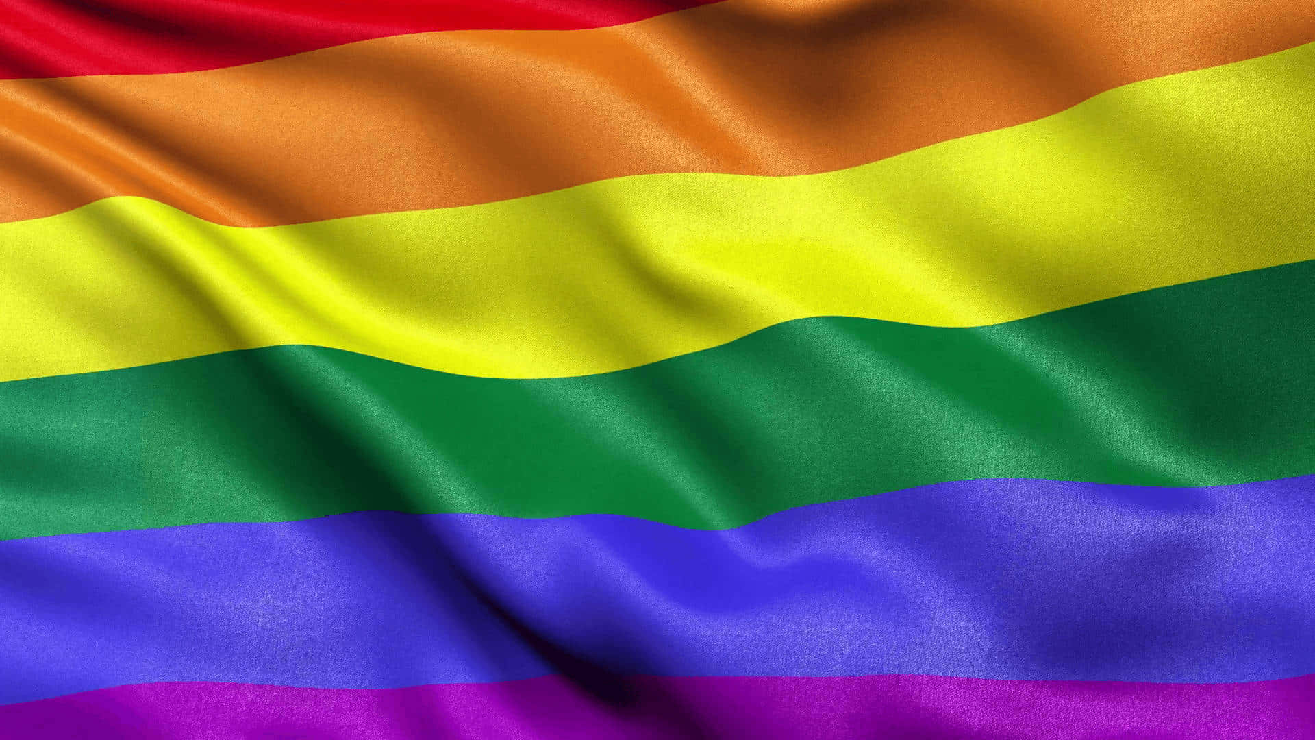 LGBT 桌布 壁紙 — 一面充滿活力的彩虹旗，帶有流暢的布料褶皺，在其六條大膽的條紋上捕捉光線。