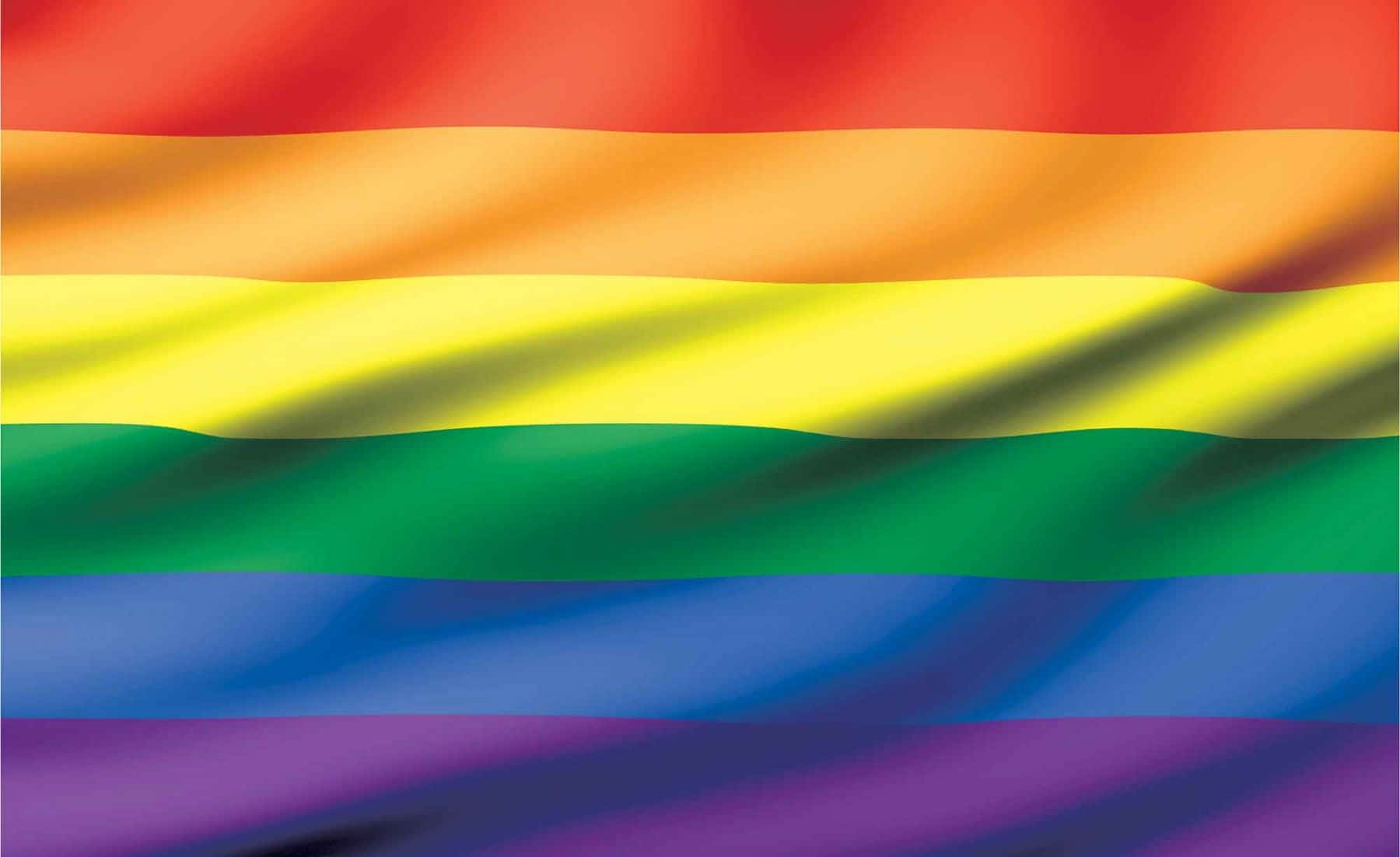 LGBT 桌布 壁紙 — 一面充滿活力的彩虹旗動態飄揚，色彩豐富飽和，營造出關於驕傲與多元的強烈視覺宣言。