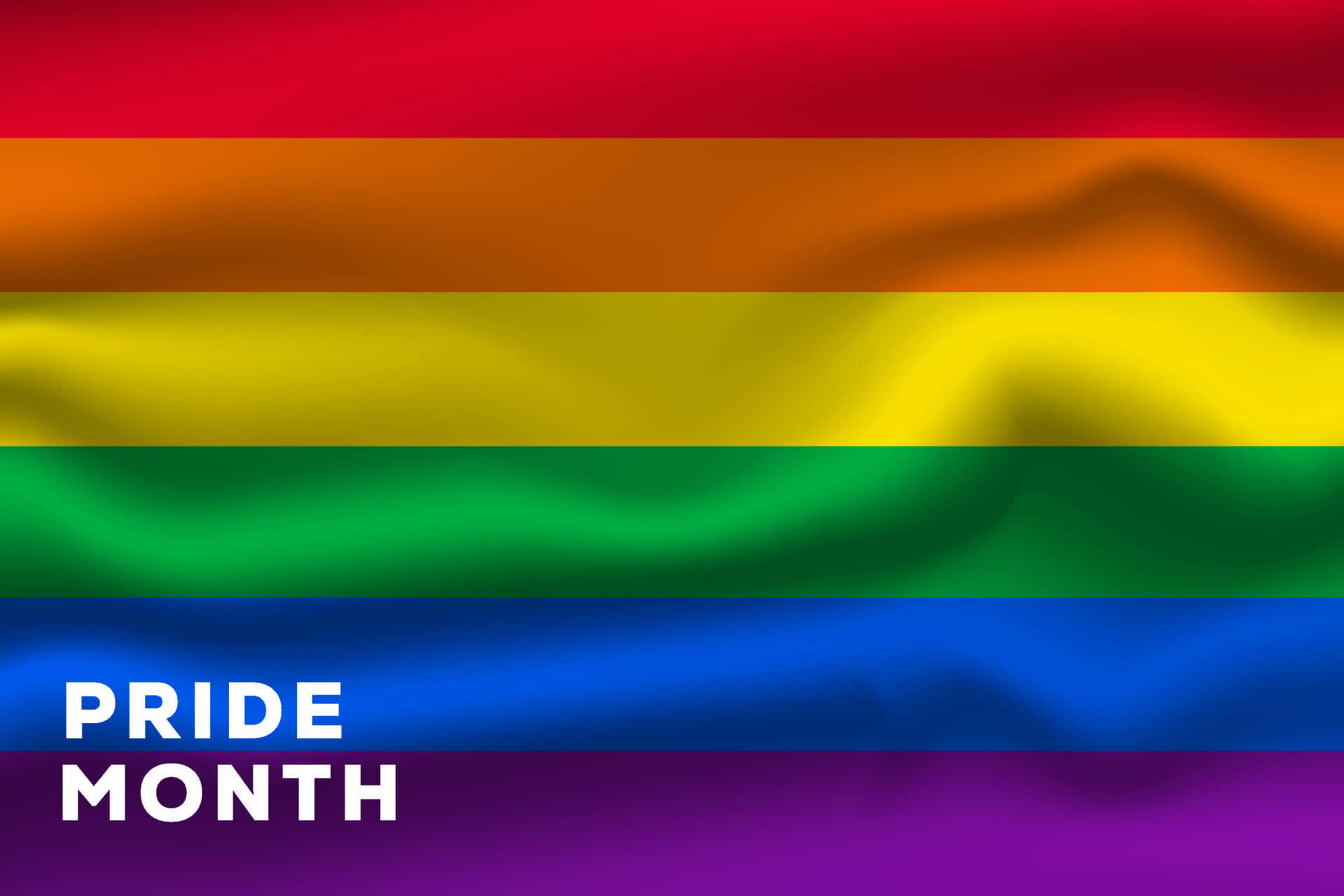 Pride Flag 桌布 壁紙 — 一面充滿活力的彩虹旗隨風飄揚，帶有柔軟的褶皺，底部有粗體白色文字寫著 PRIDE MONTH。