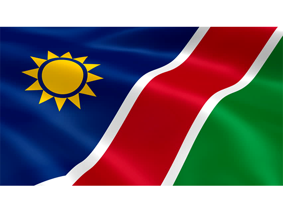 Namibia 桌布 壁紙 — 一面充滿活力的納米比亞國旗在純白背景上動態飄揚，展示大膽的紅色、綠色、藍色和黃色。