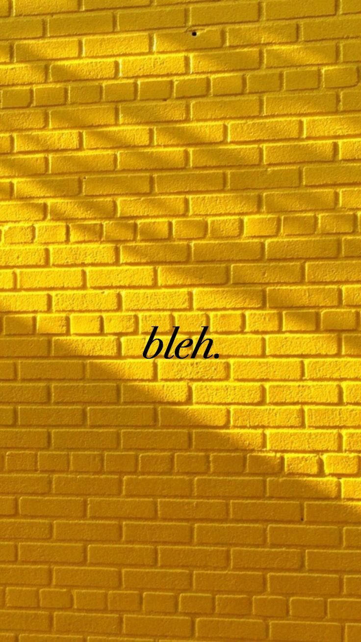 Brick 桌布 壁紙 — 一面充滿活力的黃色磚牆，帶有對角線陰影和黑色字體的「bleh」字樣。