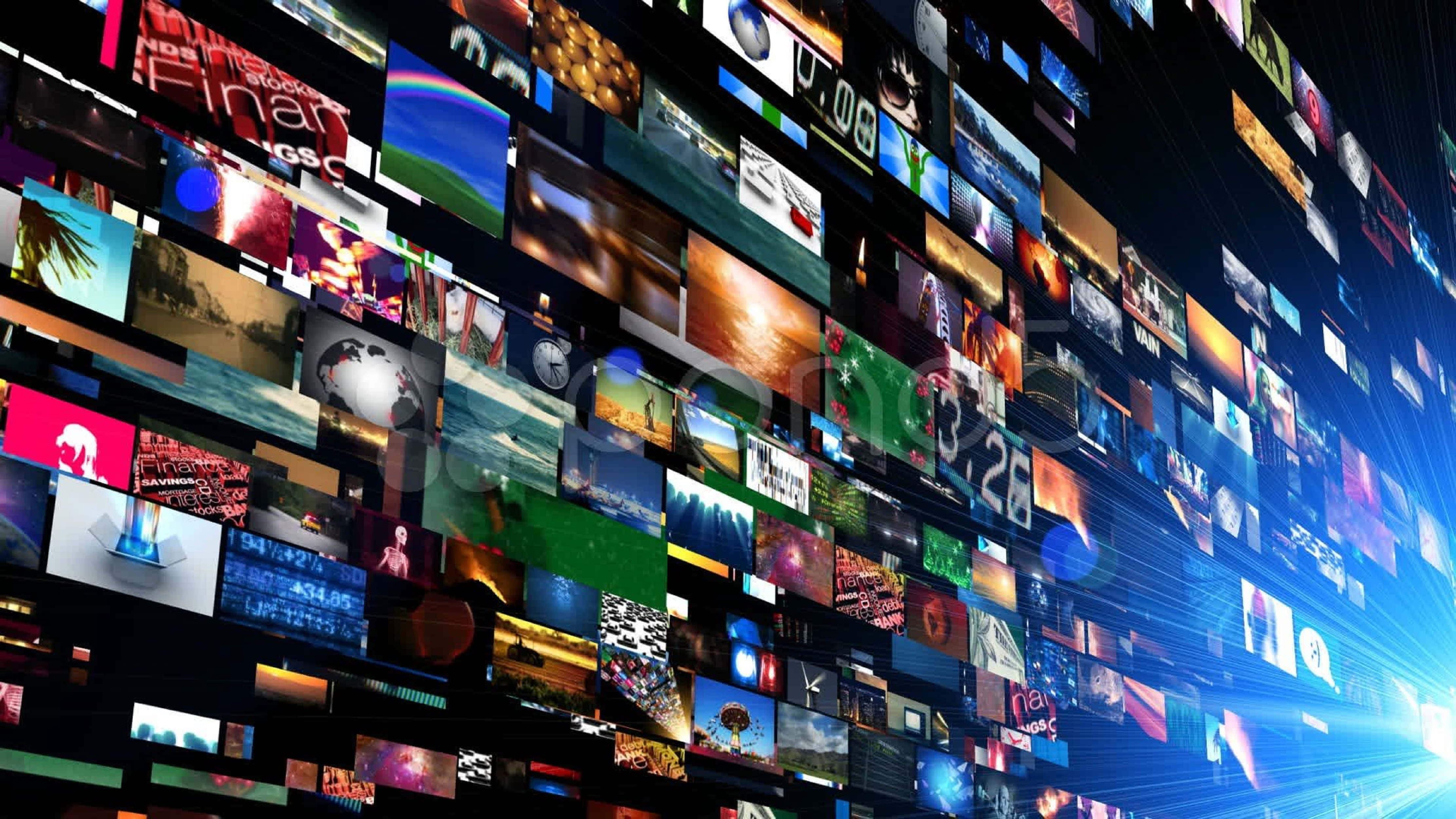 4K Streaming 桌布 壁紙 — 一面動態的數位牆，由發光的螢幕組成，在黑暗背景中顯示多樣內容，並帶有藍色光線。